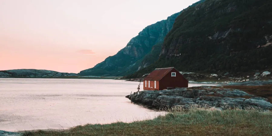 A picturesque Scandinavian house in Norway, poised gracefully on the water's edge.