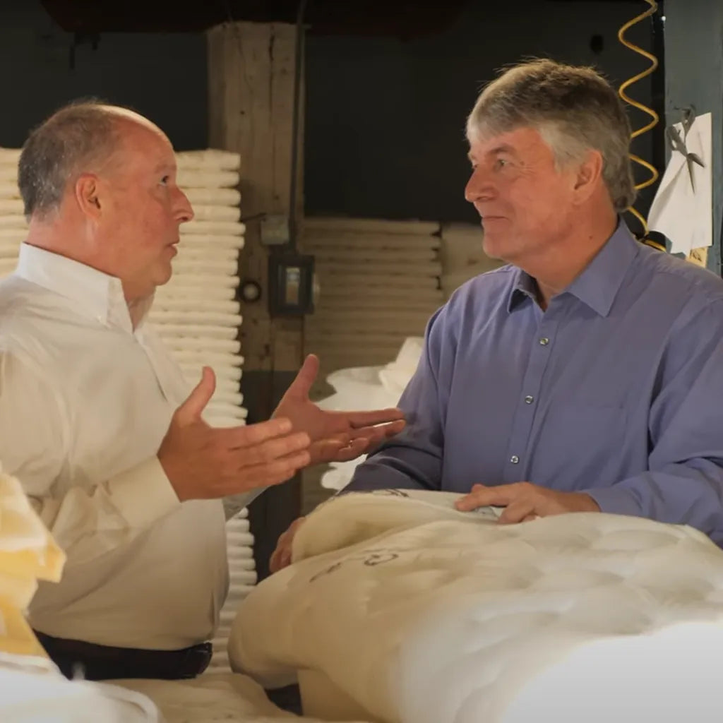 Vice President of DLX discussing mattresses with a customer in the factory. Contact us to connect.