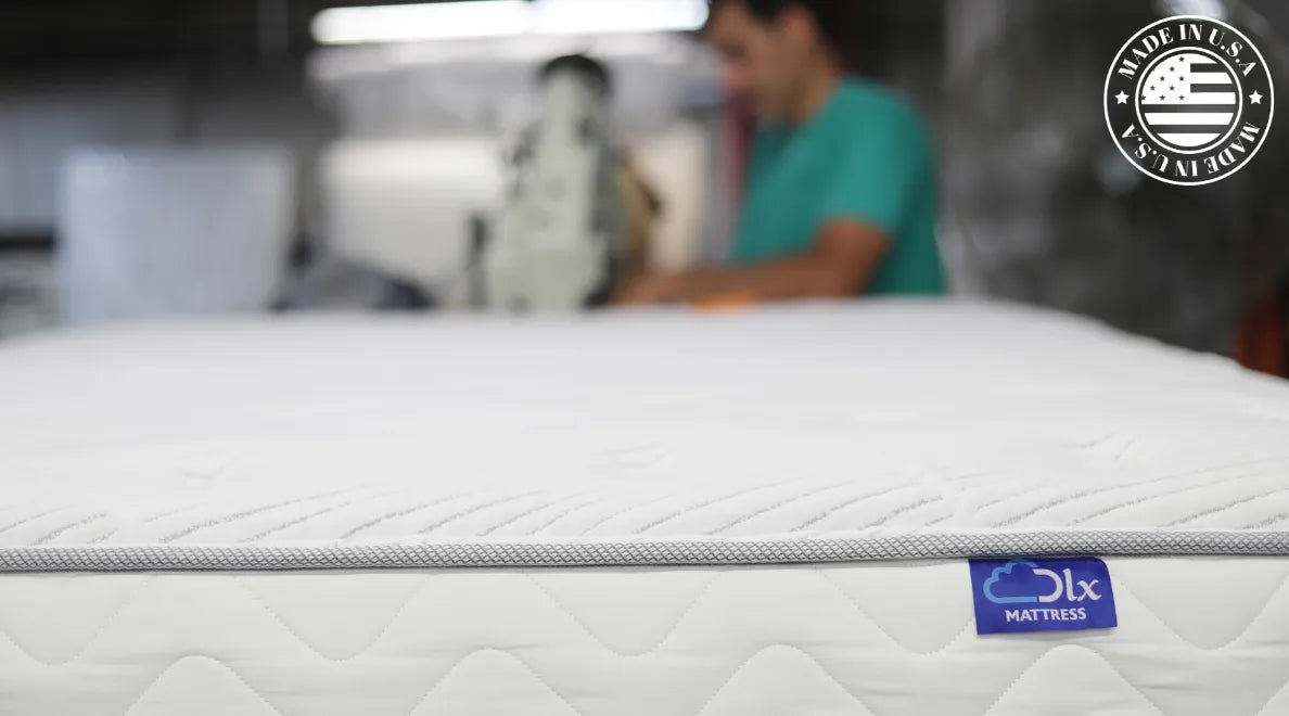 DLX mattress being tape edged, showcasing the blue label and 'Made in the USA' logo