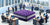 A conceptual image of a purple mattress in the middle of a bank office, symbolizing Purple Innovation's debt refinancing strategy.