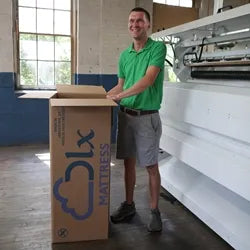 Aaron Pullan, third generation mattress maker, boxing a deluxe mattress with precision