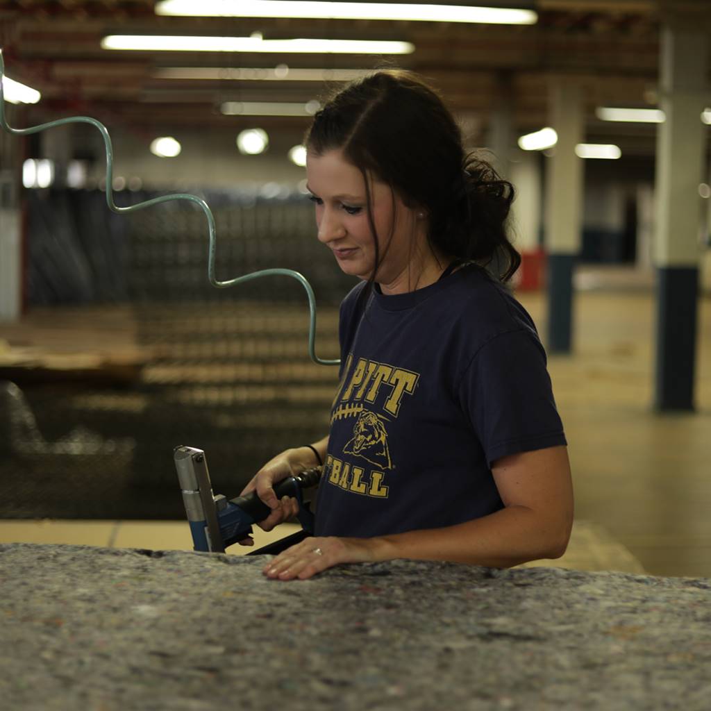 Women building a mattress inside a factory in the United States