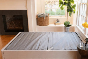 DLX Mattress Foundation displayed in a cozy living room, acting as a sturdy box spring replacement for improved mattress support.