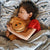 Happy boy reviewing the comfort of the DLX mattress while snuggling with his teddy bear.