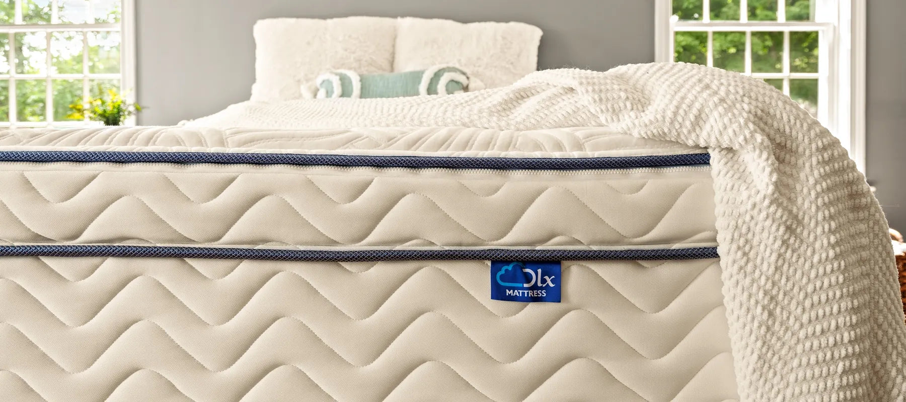 Close-up view of the DLX hybrid mattress showing the distinct blue DLX logo label.
