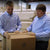Two workers packing a DLX mattress for delivery, ensuring a safe transition to a customer's home.