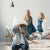 Father and kids enjoying a pillow fight on DLX mattress with commitment to low pricing