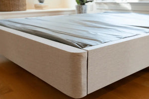 Corner view of DLX Mattress Foundation, highlighting the upholstered fabric and solid structure as a box spring alternative.