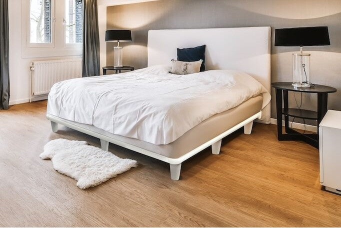 Contemporary bedroom setup with the Knickerbocker emBrace 360 Platform Bed in white, paired with a minimalist headboard and modern black accent lamps.