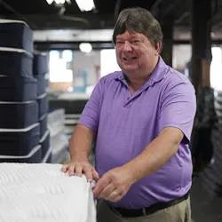 Steve Pullan, Plant Manager, actively working on the tape edge machine.